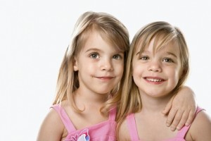 Duas crianças sorridentes, abraçadas